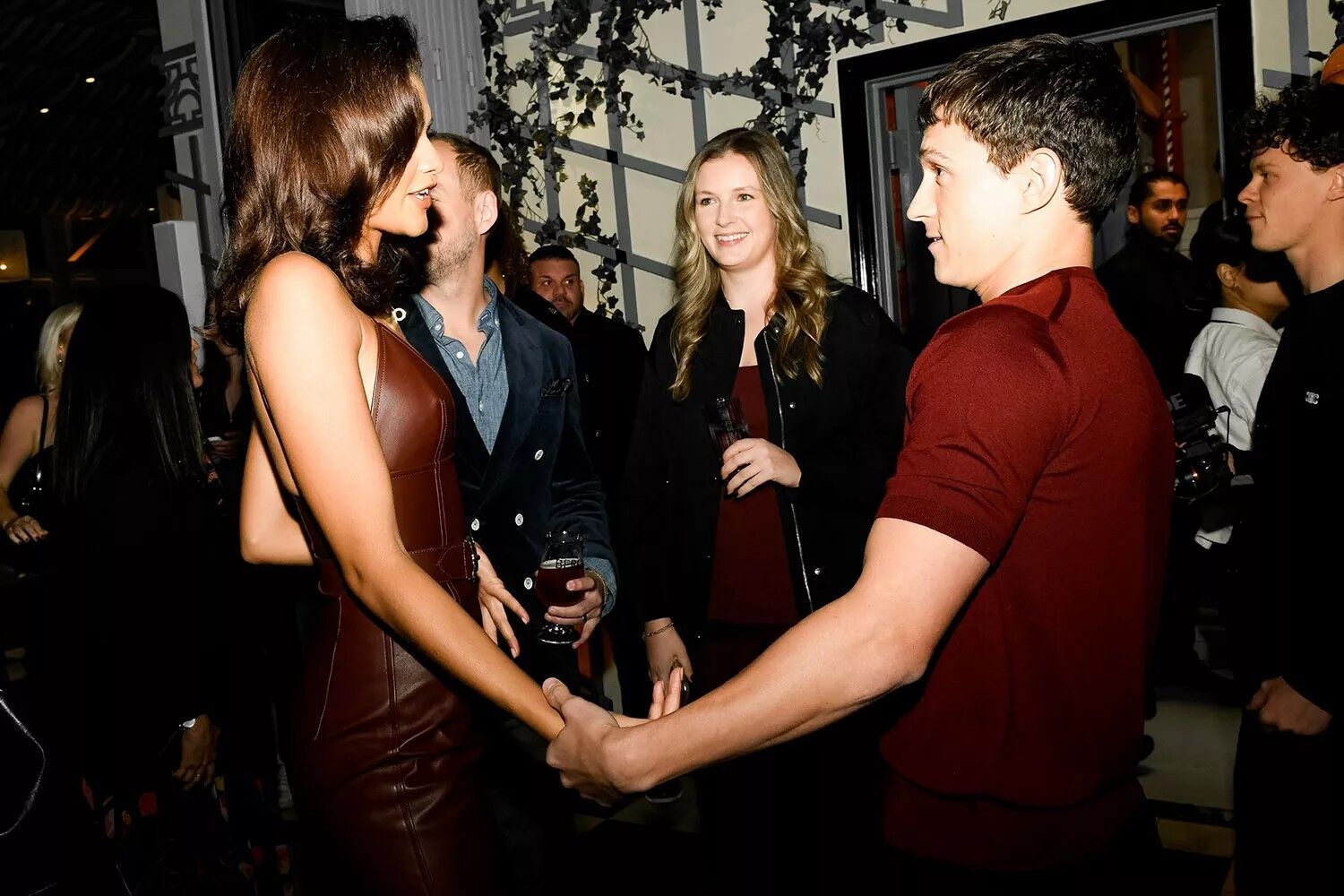 Zendaya (left) holds hands with Tom Holland.