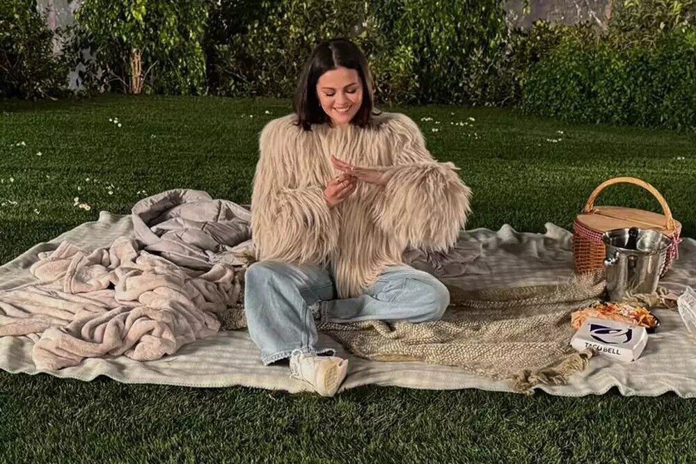 Selena Gomez having a picnic while looking at her engagement ring.