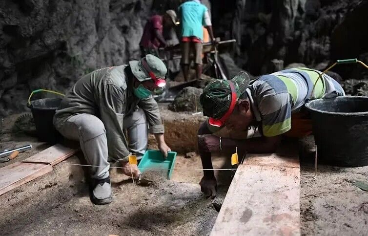 Archaeologists Daud Tanudirjo and Moses Dailom excavating at Mololo Cave