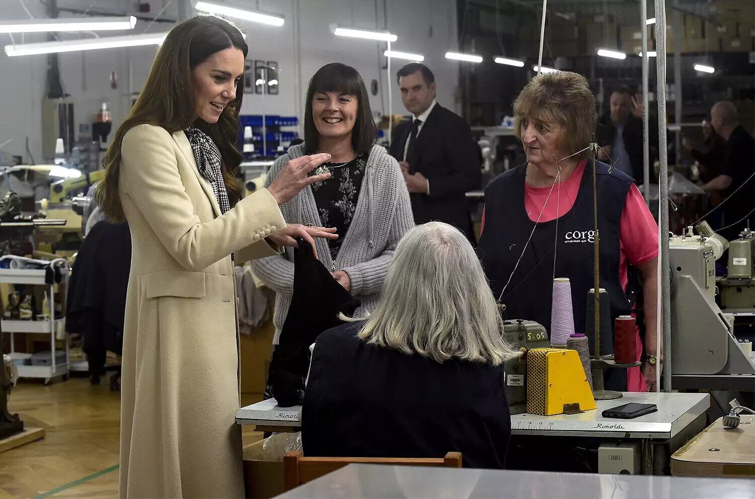 Catherine, Princess of Wales (L) spends time with members of the production team on the factory floor during a visit to Corgi, a family run textiles manufacturer focused on the production of socks and knitwear on Jan. 30, 2025 in Ammanford, Wales