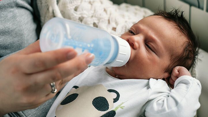 A newborn drinks from the bottle