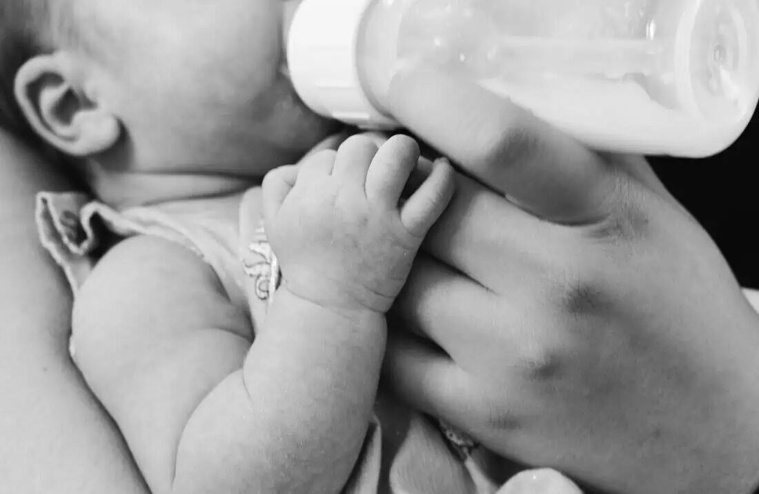 A newborn drinks from the bottle