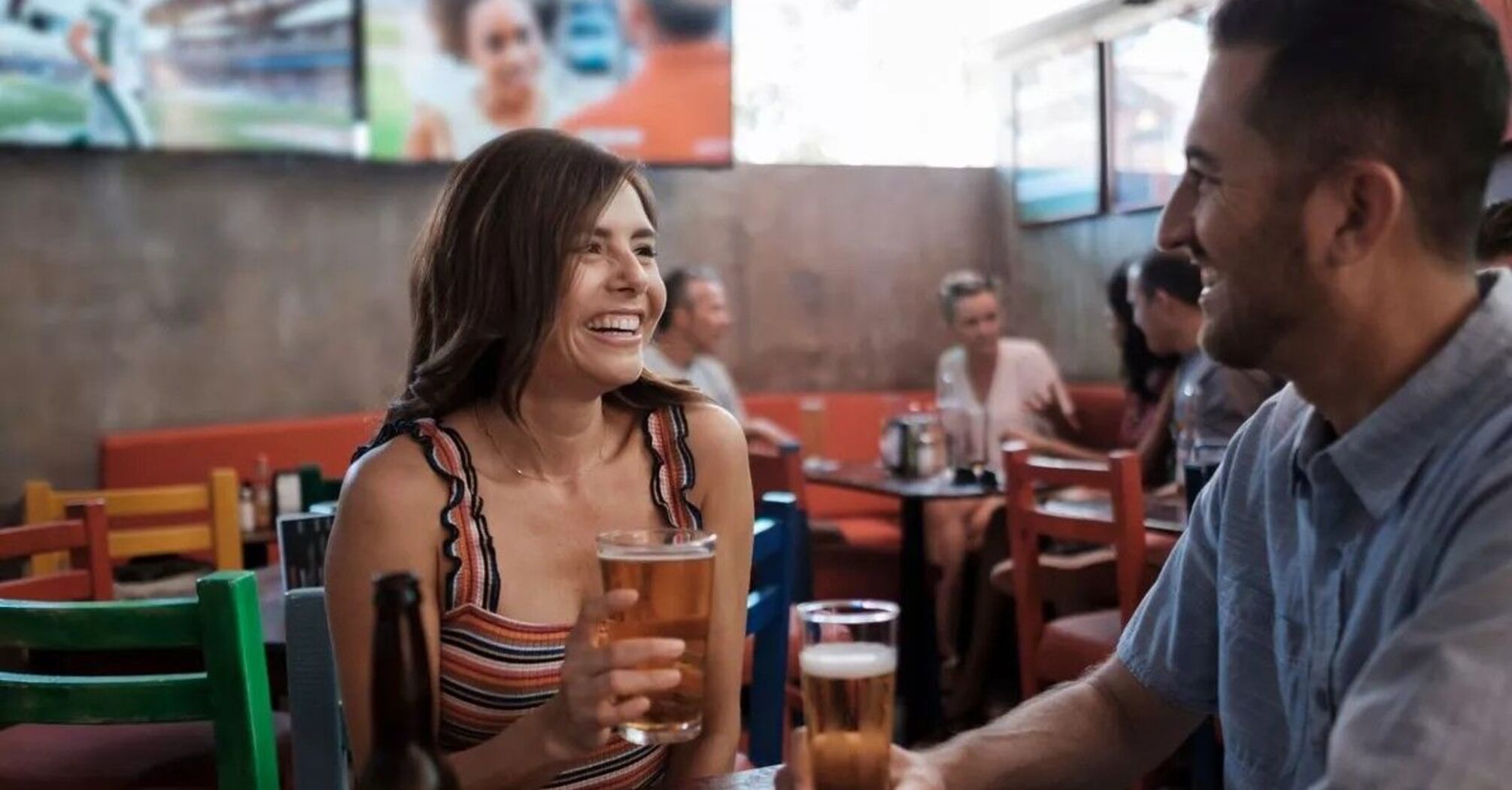 Happy couple drinking beer in bar